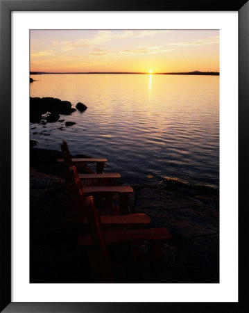 Two Empty Wooden Chairs Sit On Maine's Rocky Coast As The Sun Sets Over The Horizon by Tim Laman Pricing Limited Edition Print image