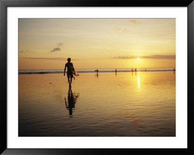 A Surfer With A Surfboard In Hand Walks Toward The Ocean At Sunset by Eightfish Pricing Limited Edition Print image