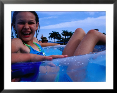 Young Girl Floating In Swimming Pool In Rubber Ring, Gold Coast, Australia by Richard I'anson Pricing Limited Edition Print image