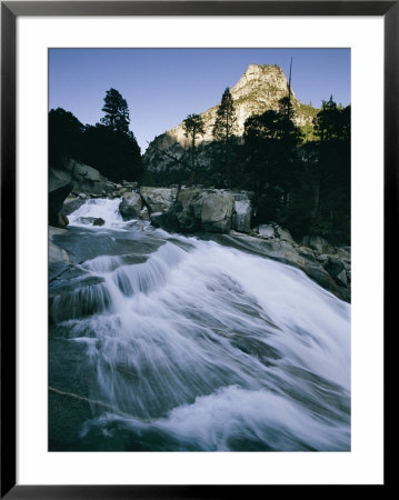 Water Rushes Down A Steep Slope Beneath A Sunlit Peak by Phil Schermeister Pricing Limited Edition Print image