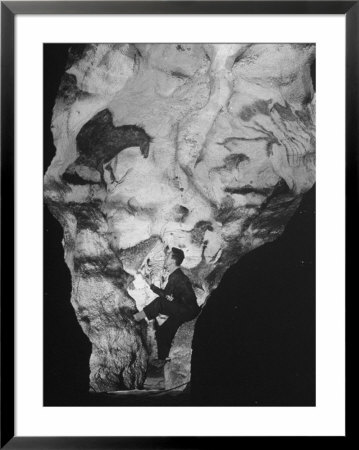 Man Looking At Prehistoric Cave Painting by Ralph Morse Pricing Limited Edition Print image
