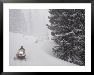 A Group Of Snowmobilers Turn A Corner In A Snowstorm by Taylor S. Kennedy Pricing Limited Edition Print image