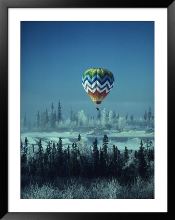 Hot Air Balloon Hovers Over A Snowy Landscape by George Herben Pricing Limited Edition Print image