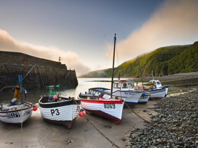 Fishing Vessels Beached At Low Tide In Clovelly Harbour, Devon, England by Adam Burton Pricing Limited Edition Print image
