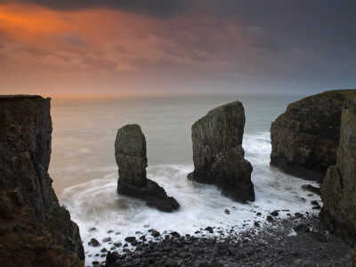 Rock Stacks Guard The Entrance To A Secluded Pembrokeshire Cove, Wales by Adam Burton Pricing Limited Edition Print image