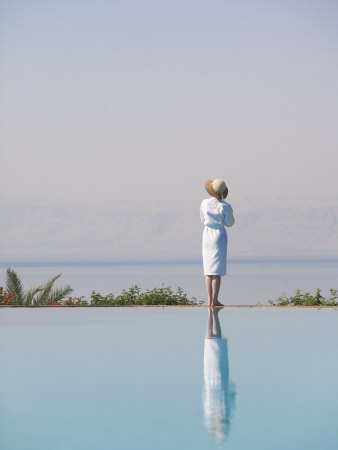 Woman Enjoys The Warm Sun On The Edge Of A Pool by Taylor S. Kennedy Pricing Limited Edition Print image