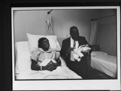 Laura Price Watching Husband Ernest Hold Their Baby Son, Ernest Jr., At Jackson Memorial Hospital by Lynn Pelham Pricing Limited Edition Print image