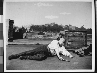 Lying On A Roof With Six-Shooter And Knife, Dressed In A Western-Style Outfit For A Costume Study by Wallace G. Levison Pricing Limited Edition Print image