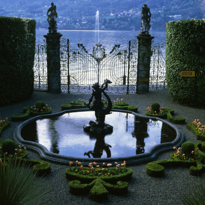 Fountain Surrounded By Beds Filled With Tulip Orange Favourite At Villa Carlotta, Lake Como, Italy by Clive Nichols Pricing Limited Edition Print image