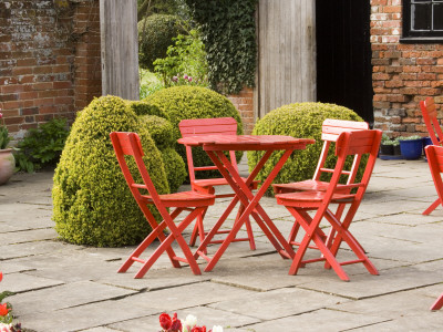 Terrace With Red Table And Chairs, Box Topiary And Tulips by Clive Nichols Pricing Limited Edition Print image