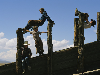 Young Cowboys Playing On A Cattle Chute by Melissa Farlow Pricing Limited Edition Print image