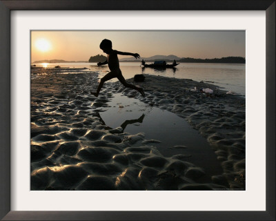 A Boy Plays On The Banks Of The River Brahmaputra In Gauhati, India, Friday, October 27, 2006 by Anupam Nath Pricing Limited Edition Print image