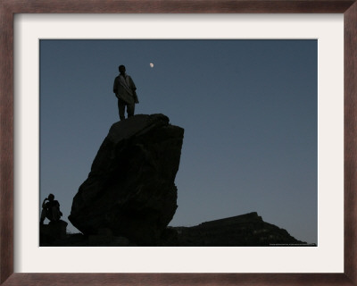 An Afghan Man Stands On A Huge Rock Next To The Now Abad Dinazung Monument by Rodrigo Abd Pricing Limited Edition Print image