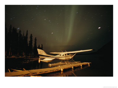 The Aurora Borealis Glows Brightly Over A Seaplane Docked On Cli Lake by Raymond Gehman Pricing Limited Edition Print image
