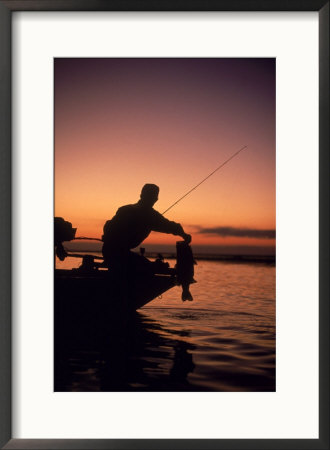 Silhouette Of Bass Fisher At Sunset by Timothy O'keefe Pricing Limited Edition Print image