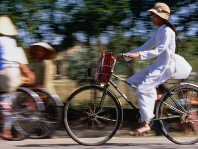 Girl Riding Bike, Ho Chi Minh, Vietnam by John Borthwick Pricing Limited Edition Print image