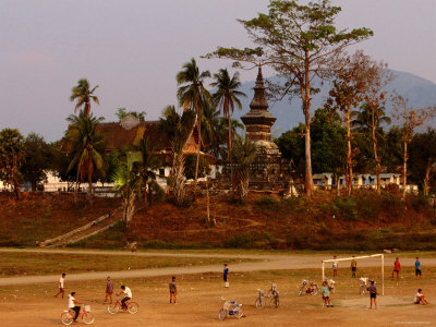 Boys Playing In Front Of That Luang Temple, Luang Prabang, Laos by Alain Evrard Pricing Limited Edition Print image