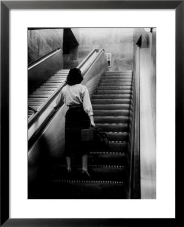 Woman Riding On Escalator In The Time And Life Building by Nina Leen Pricing Limited Edition Print image