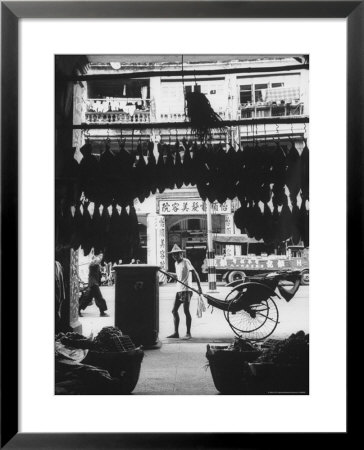 Young Man Standing In Front Of A Herbs And Fish Market Displaying Racks Of Fish by Howard Sochurek Pricing Limited Edition Print image