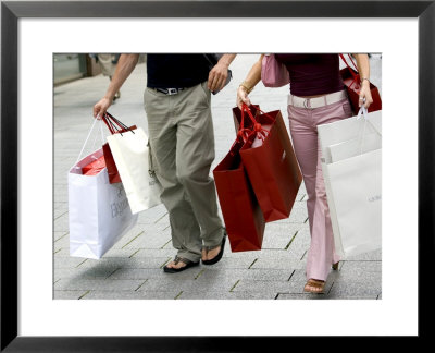 Couple Walking With Shopping Bags On Konigsallee, Dusseldorf, North Rhine Westphalia, Germany by Yadid Levy Pricing Limited Edition Print image