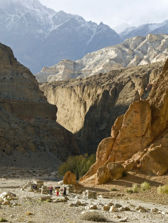 Distant Hikers In A Gorge, Mustang, Nepal, Peaks In Background by Stephen Sharnoff Pricing Limited Edition Print image