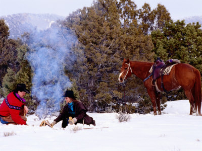 Cowboy With Cowgirl Sitting Near Camp Fire In Snow, Their Horse Standing Nearby, U.S.A. by Curtis Martin Pricing Limited Edition Print image