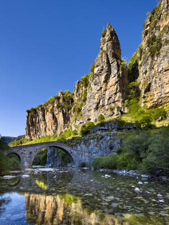 Towering Cliffs And The 18Th Century Misius Bridge Over The Voidomatis River In The Vikos Gorge Nea by Lizzie Shepherd Pricing Limited Edition Print image