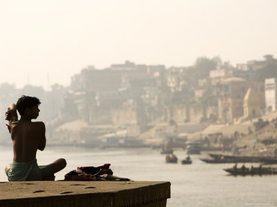 Man Stretching During His Morning Yoga Exercises Overlooking The Holy River Ganges by Gavin Gough Pricing Limited Edition Print image