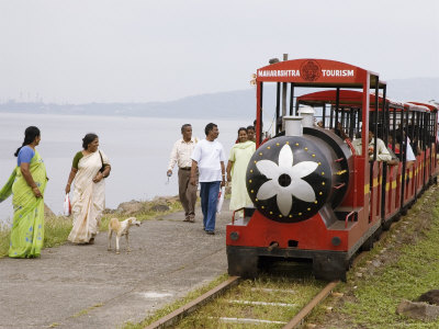 People Walk Next To Miniature Train Near Elephanta Island by Mick Elmore Pricing Limited Edition Print image