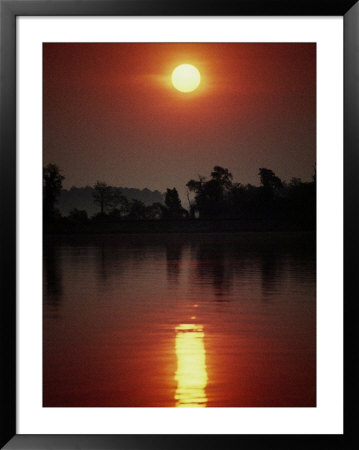 A Fiery Sun Rises Above The Tree-Lined Shore Of The Wye River by Stephen St. John Pricing Limited Edition Print image