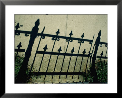 The Shadow Of A Wrought-Iron Fence Throws A Pattern Across The Sidewalk by Stephen St. John Pricing Limited Edition Print image