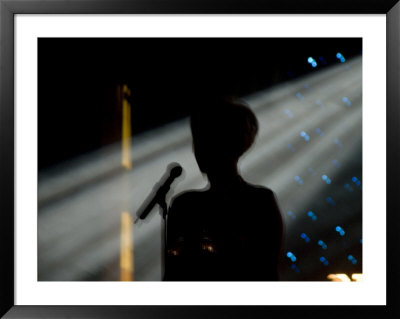 Female Singer And Microphone Silhouetted With Stage Lights by Todd Gipstein Pricing Limited Edition Print image