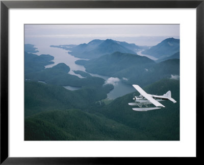 A Beaver Airplane On Floats Flies Over Islands And Snowy Mountains by Joel Sartore Pricing Limited Edition Print image