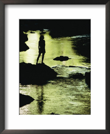 A Woman Is Silhouetted Standing On A Rock Jutting Out From A Stream by Barry Tessman Pricing Limited Edition Print image