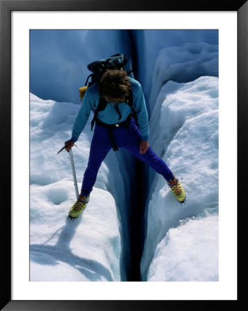 A Climber Steps Over A Crevasse In Root Glacier by Rich Reid Pricing Limited Edition Print image
