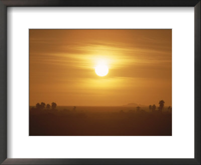 The Setting Sun Casts A Hazy Orange Glow Over The Sahara Desert by Peter Carsten Pricing Limited Edition Print image