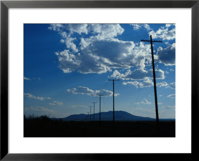 Silhouetted Telephone Poles Under Puffy Clouds by Raymond Gehman Pricing Limited Edition Print image