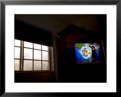 Stormy View Outside Window With Television Displaying A Hurricane Watch by Raul Touzon Pricing Limited Edition Print image