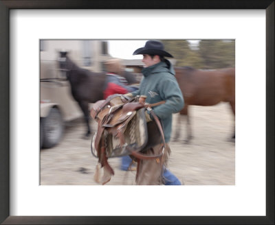 A Male Rancher Lifts A Saddle At The Nebraska National Forest by Joel Sartore Pricing Limited Edition Print image