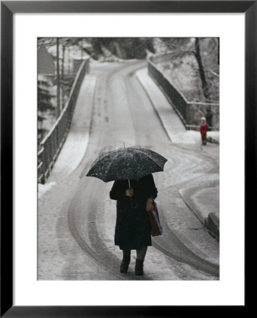 Older Woman Walking In The Snow With An Umbrella by Sam Abell Pricing Limited Edition Print image