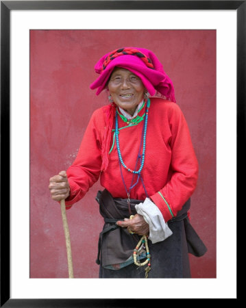 Elderly Tibetan Woman With Red Wall, Tagong, Sichuan, China by Keren Su Pricing Limited Edition Print image