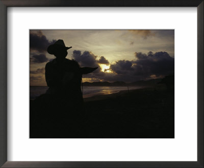 A Cowboy On His Horse Enjoys Sunrise On A Beach by Raul Touzon Pricing Limited Edition Print image
