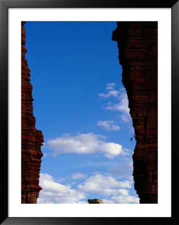 Climbers Scale The Sharks Fin, A Rock Formation In Monument Basin by Bill Hatcher Pricing Limited Edition Print image