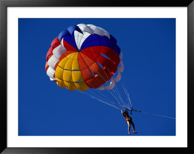Person Parasailing In Sky Off The Beach, Indonesia by Nicholas Reuss Pricing Limited Edition Print image