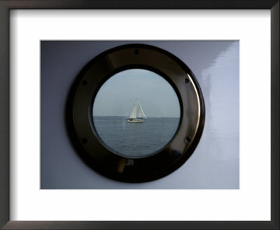 A Porthole Provides A Brass Frame For A Passing Sailboat by Stephen St. John Pricing Limited Edition Print image