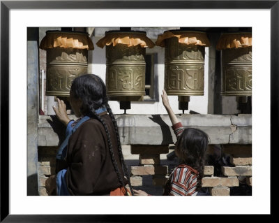 Buddhist Woman And Child Spin Brass Prayer Wheels, Qinghai, China by David Evans Pricing Limited Edition Print image