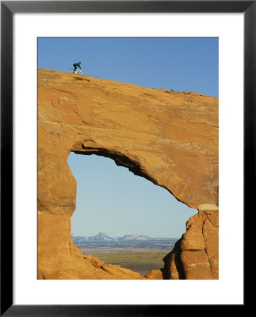 Brad Richman Rides His Bicycle Over Hole In The Rock Formation by Bill Hatcher Pricing Limited Edition Print image