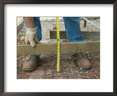 Man Measures A Wood Frame Before Pouring Concrete by Joel Sartore Pricing Limited Edition Print image