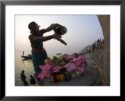Woman Pouring Water Over Flowers On An Altar As A Religious Ritual, Varanasi, India by Eitan Simanor Pricing Limited Edition Print image