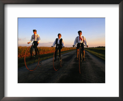 A Family, Dressed In Period Attire, Ride Old-Fashioned Bicycles Dating From The Late 1800S by Melissa Farlow Pricing Limited Edition Print image
